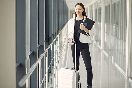 机场有手提箱的女人航空公司旅行窗户女士成人大厅旅游女孩行李假期图片