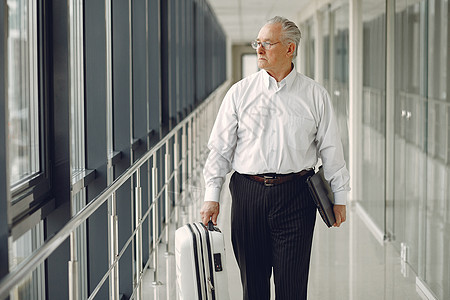 机场高贵的老人 拿着手提箱男人手提箱眼镜乘客行李商务运输人士成人笔记本图片