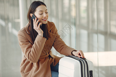 机场有手提箱的女人大厅商业窗户游客人士旅行假期女孩旅游电话图片