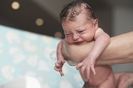 刚出生的女婴第一次洗澡女儿保健妈妈父母幸福浴缸母亲卫生童年女孩图片