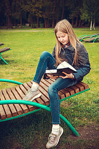 学龄女童坐在公园的木机窗上看书 坐着看书图片