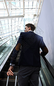 机场的商务人士在电梯下爬梯上航班细胞自动扶梯人士男人电话沟通办公室主席商务图片