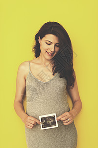 显示超声波照片的孕妇妈妈微笑怀孕成人姿势冒充母亲女孩身体扫描图片