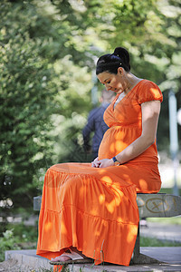 怀孕期橙子女性卫生微笑喜悦父母婴儿妈妈草地姿势图片