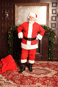 传统的圣诞老人站在壁炉旁边 圣诞树在房间里 笑声父亲假期庆典胡须解雇邮件魔法戏服礼物新年图片
