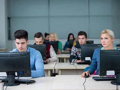 计算机实验室教室中的学生组群快乐监视器工作桌子计算学习房间互联网同学屏幕图片