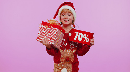红圣诞礼帽的女孩女孩显示礼物盒和70%的贴贴画标语文本注纸图片