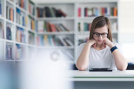 使用平板电脑在学校图书馆学习的女学生技术眼镜女性学校知识家庭作业青年文学研究成人图片