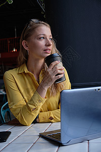 年轻的白人美女坐在咖啡馆里 拿着笔记本电脑和一杯咖啡衬衫人士商业职场商务杯子企业家公共场所桌子女士图片