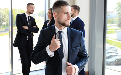 年轻的商务人士和他关于背景的学术会议一起在办公室里站着成人合作团体经理专家商务男性就业合伙工作图片