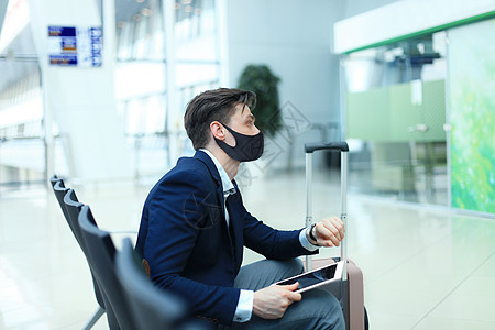 戴保护面具和手提箱的商务人士在机场大厅里 在科罗纳病毒流行的机场空气护照经理旅行运输技术行李飞机套装男人图片