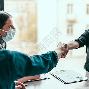 金融伙伴们在握手 彼此握手商务男人防护手势会议经理流感讨论雇员桌子图片