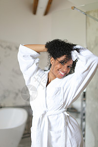 年轻的黑人女孩穿着浴袍 在浴室里跳着舞图片