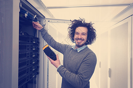 使用数字电缆分析器的技师男人服务器技术员电缆控制数据技术公司路由器网络图片