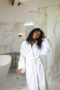年轻黑人女孩穿着浴袍 站在浴室里图片