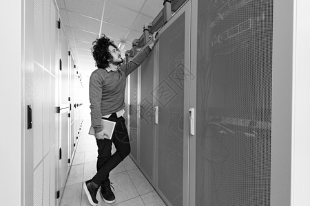 信息技术工程师在服务器机房使用平板电脑硬件中心房间通讯路由器男人人士互联网工作解决方案图片