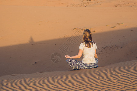 青春女子在日落时沉思赤沙沙漠图片