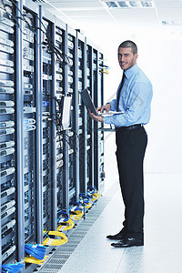拥有网络服务器机房膝上型电脑的商务人士电缆硬件架子数据中心工程师路由器防火墙服务技术数据图片