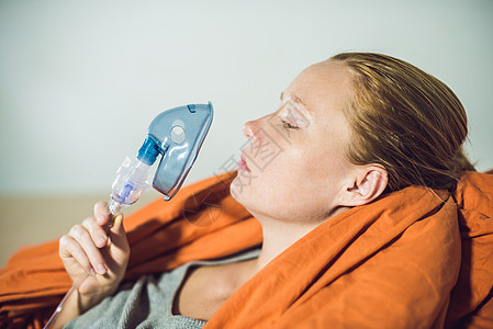 有流感或感冒症状的妇女用雾化器吸入  医学吸入疗法诊所喷雾器女士传染毯子办公室面具药品药物空气图片