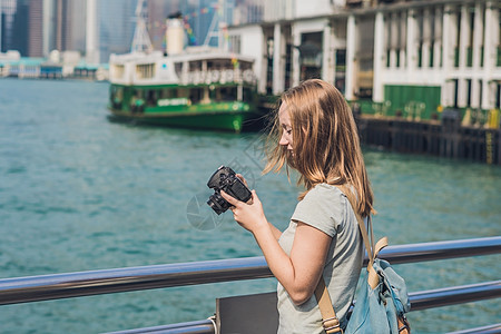 在中国香港拍摄胜利港照片的年轻女青年 女士天际港口旅行手机金融城市相机女孩建筑学商业图片