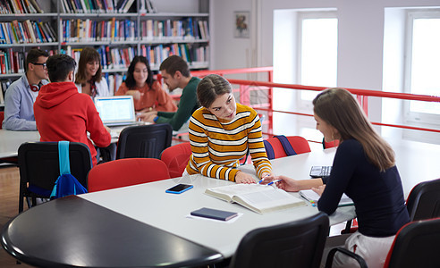 学生小组在现代大学的平板电脑上一起研究学校项目技术阅读团队考试桌子教育绘画朋友们女性男人图片