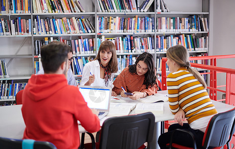 学生小组在现代大学的平板电脑上一起研究学校项目桌子文书教科书教育考试技术工作绘画女性团队图片