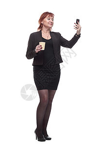 带着智能手机和咖啡的笑容女商务人士带走夹克商业管理人员工人成人女性衣服广告牌互联网饮料图片