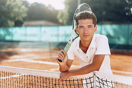 在网球场站着电击的年轻混种男子网球运动员红土混血教练老师运动男人玩家法庭人手背景图片