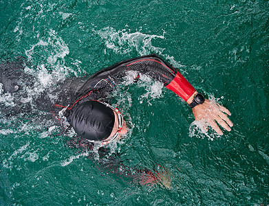 身穿湿衣在湖上游泳的三亚体运动员游泳衣潜水行动竞赛运动装训练男人钢铁侠耐力铁人图片