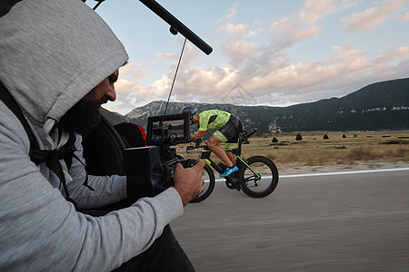 电影摄影师拍摄三亚特隆自行车运动员的动作行动摄影视频驾驶头盔生产运动钢铁侠训练制片人图片