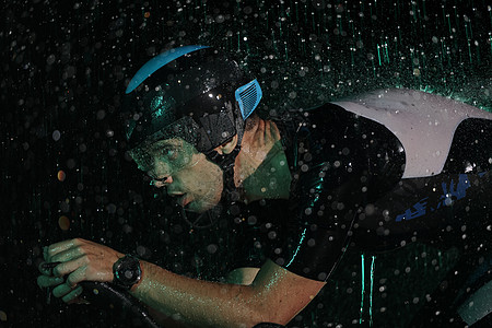 在雨夜快速骑着自行车的三亚马龙运动员铁人速度头盔天气耐力运动黑色赛车手活力竞赛图片