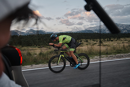 电影摄影师拍摄三亚特隆自行车运动员的动作驾驶速度制片人摄影男人铁人头盔生产行动训练图片