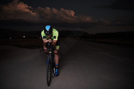 夜里快速骑自行车的三重运动员行动钢铁侠活力黑色耐力运动速度竞赛凝胶男人图片