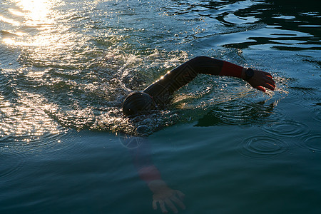 海里游泳穿着湿衣服在日出湖上游泳的三亚体运动员游泳者游泳衣男人风镜运动钢铁侠运动装活力锻炼潜水背景