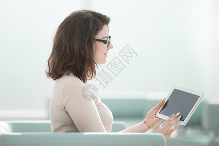 拥有数字平板电脑的女商务人士 坐在办公室里图片