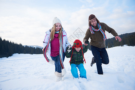 寒冬在雪中玩在一起的幸福家庭女士母亲男性孩子们女性公园男生喜悦儿子假期图片