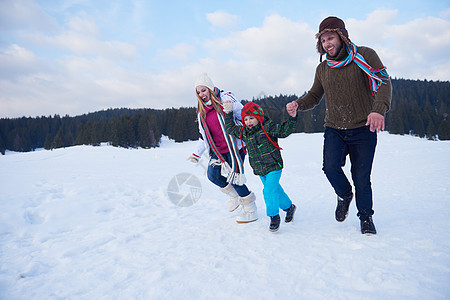 寒冬在雪中玩在一起的幸福家庭假期孩子们父亲女性母亲女孩公园建筑森林女儿图片