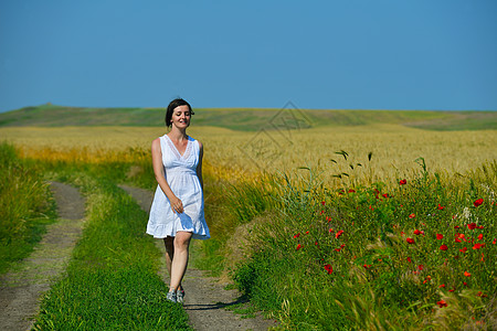 绿色田中的年轻快乐的女青年蓝色闲暇女孩女士活力自由草地跑步乐趣天空图片