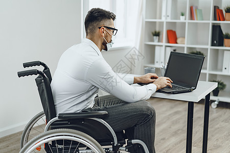 从事工作的残疾商务人士和戴医疗面罩的残疾人商务桌子面具就业经理男人残障电脑男性员工图片