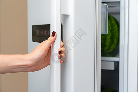 女用手打开冰箱的门图片