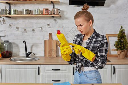 职业年轻女性戴着黄色橡胶防护手套 在厨房里拿着洗瓶器主妇抹布围裙女佣管家工具家务服务洗涤剂海绵图片