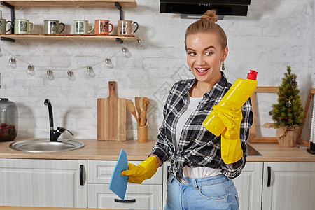 职业年轻女性戴着黄色橡胶防护手套 在厨房里拿着洗瓶器洗涤剂卫生围裙主妇房子清洁工家政橡皮女孩家庭图片