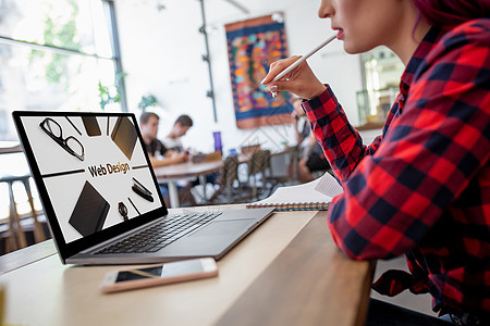 在现代咖啡厅内地酒吧工作时使用笔记本电脑的年轻女性被剪裁的画面 设计小样金融网络程序键盘消息屏幕空格处广告无线图片