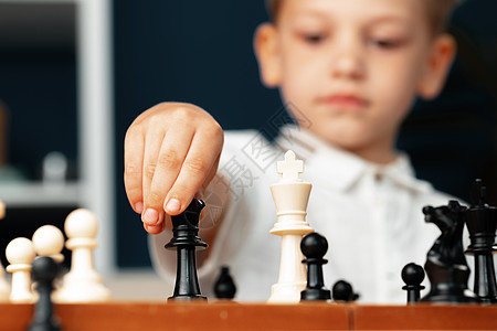 贴近一张照片 一个小男孩在下象棋思维爸爸游戏喜悦男性父母闲暇家具桌子成人图片