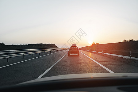 清晨在高速公路上驾驶的客车日落天空场景运输阳光运动沥青太阳旅行土地图片