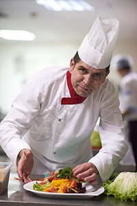 烹饪和装饰食品的厨房厨师成人蔬菜盘子工作食物帽子沙拉服务男人白色图片