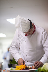烹饪和装饰食品的厨房厨师工作美食蔬菜服务餐厅沙拉酒店盘子男性帽子图片