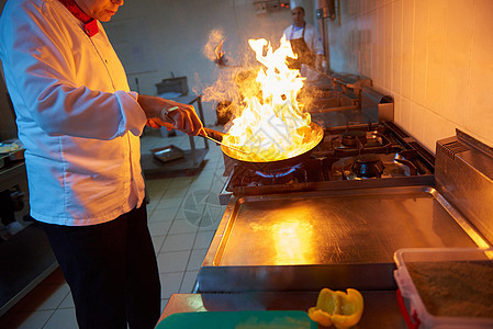 厨师在饭店厨房做饭 烧火煮饭沙拉烤箱男人美食烹饪酒店男性帽子蔬菜盘子图片