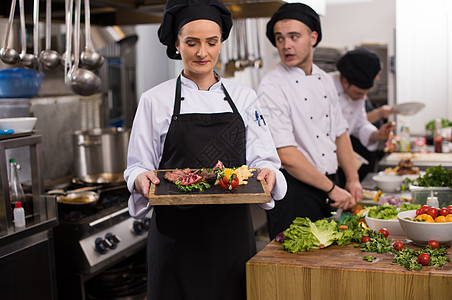 女性厨师持有牛肉牛排板餐厅食物烹饪职业商业食谱厨房美食盘子蔬菜图片