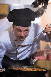 厨师用勺子品尝食物菜肴餐厅营养测试美食职员烹饪厨房男性酒店图片